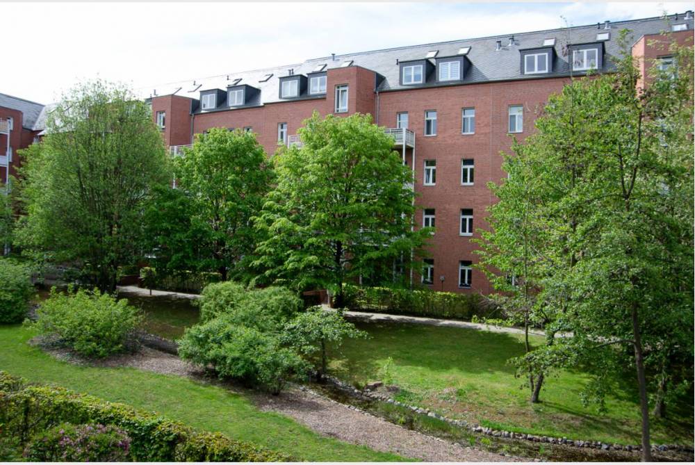 grüner Innenhof mit Bachlauf und Teichanlage